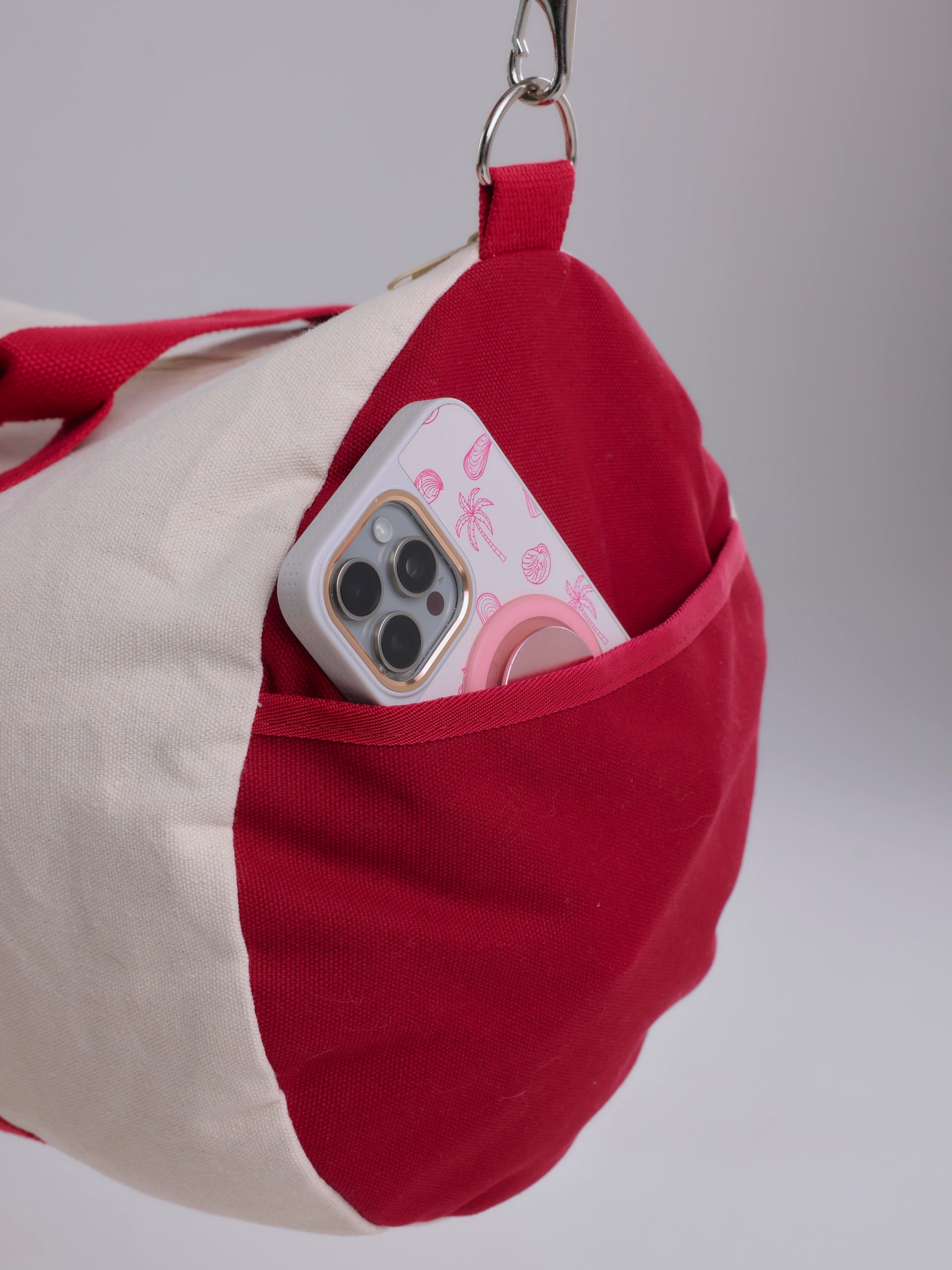 Red and beige bag with a phone inside on a gray background