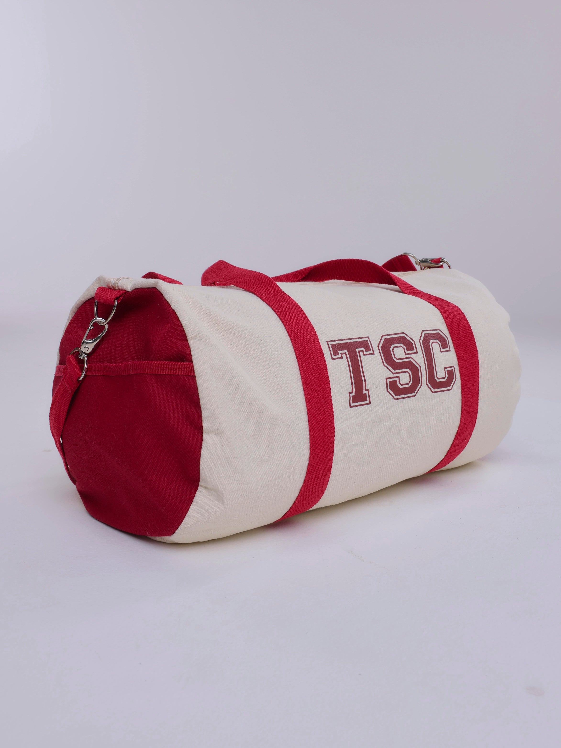 Red and white duffel bag with 'TSC' lettering on a light gray background